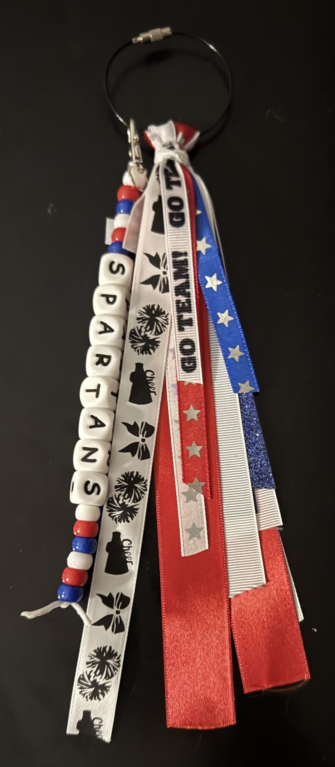 Custom SPARTANS school-swag keychain with red, white, and blue ribbons and beads